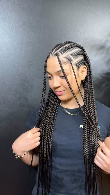 Client with long braids styled to the side, smiling softly